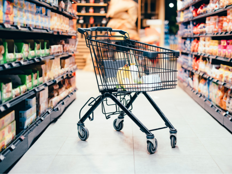 carro de compras en medio de pasillo de supermercado